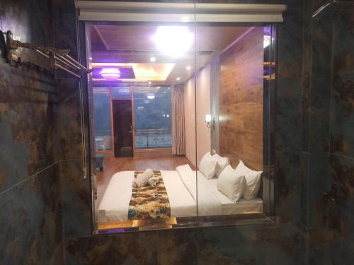 a room with a bed in a glass window at Manali mountain River Hotel & Resort in Manāli