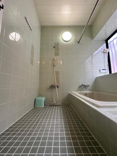 uma casa de banho com um chuveiro, uma banheira e um lavatório. em 吉祥莊 em Takayama