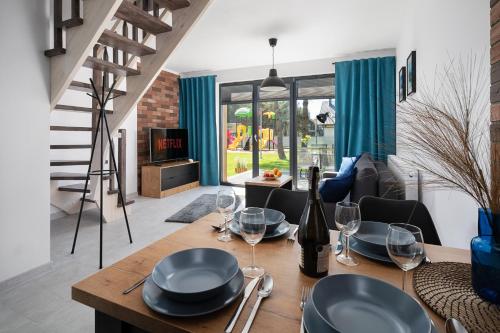 a dining room with a table with wine glasses at Domki Kos Loft in Jastrzębia Góra