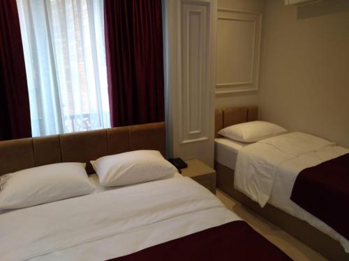 a hotel room with two beds and a window at Eyüp Sultan Hotel in Istanbul