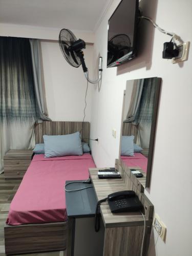 Habitación con 2 camas, escritorio y espejo. en فندق أجياد Agyad Hotel, en Asiut