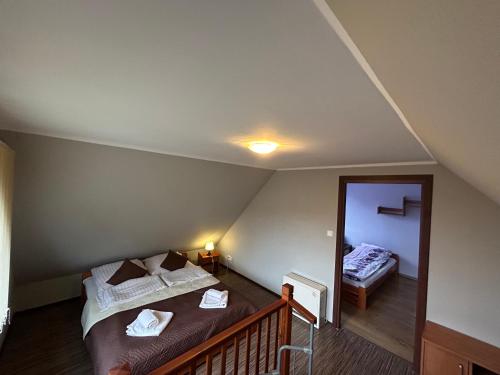 a attic room with two beds and a mirror at Apartamenty Antonio in Kudowa-Zdrój