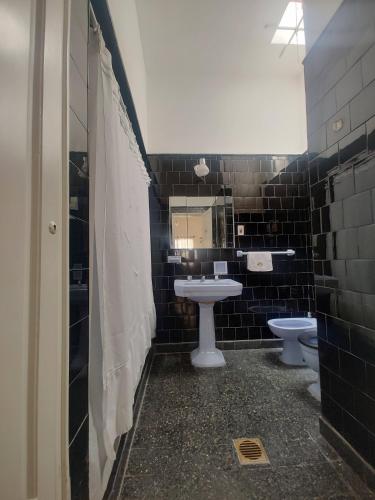 a bathroom with two toilets and a sink and a mirror at Limón Dulce Hostel in San Fernando del Valle de Catamarca