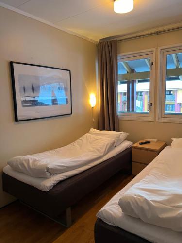 a room with two beds and a picture on the wall at Sandmoen Bed & Breakfast, Free Parking in Trondheim