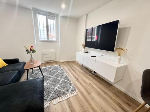 un salon avec une grande télévision à écran plat dans l'établissement L Eclat - Logement moderne proche Paris - Wifi, à Rueil-Malmaison