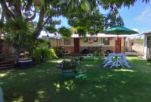 um quintal com uma mesa e um guarda-chuva em Residencial Pita em Prado