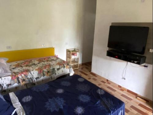 a bedroom with a bed and a flat screen tv at Residencial Pita in Prado