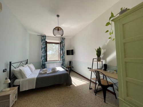 a bedroom with a bed and a table and a window at Agriturismo con cucina Il Favaio in Paciano