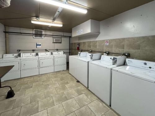 a laundry room with a bunch of white machines at Studio 6 Mesquite, TX Town East in Mesquite