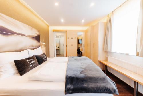 a bedroom with a large white bed and a window at Pension Linder in Seeboden