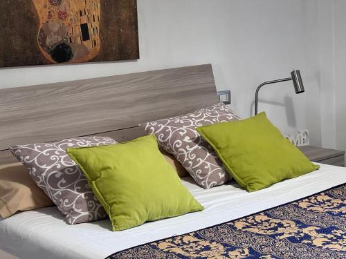 a bed with green pillows and a headboard at Casa Di TaTa in Trezzo sullʼAdda