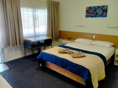 a hotel room with two beds and a desk at Oakey Motel in Oakey