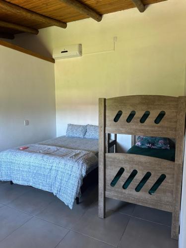 1 dormitorio con litera y silla en Casa a 50 metros do mar, en Itati