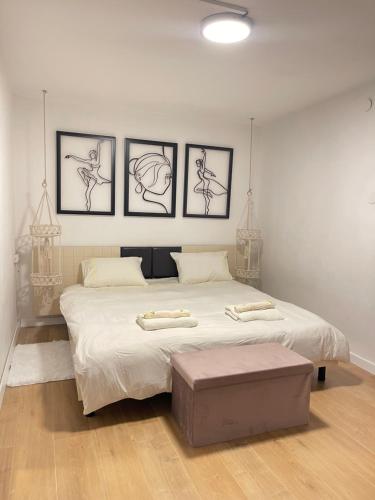 een slaapkamer met een groot bed met vier foto's aan de muur bij Butikush in Haifa