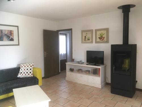 un salon avec un canapé et une télévision dans l'établissement LE TRIANGLE D'OR, à Bonrepos
