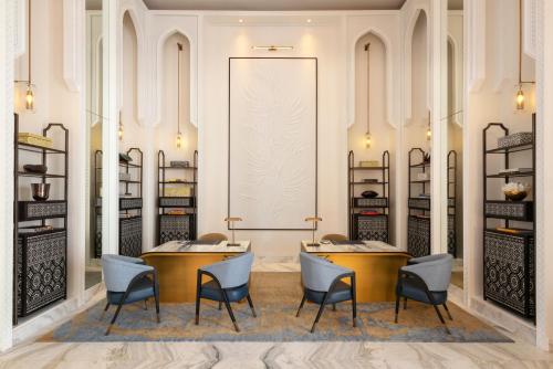 a room with two tables and chairs and shelves at Raffles Al Areen Palace Bahrain in Manama
