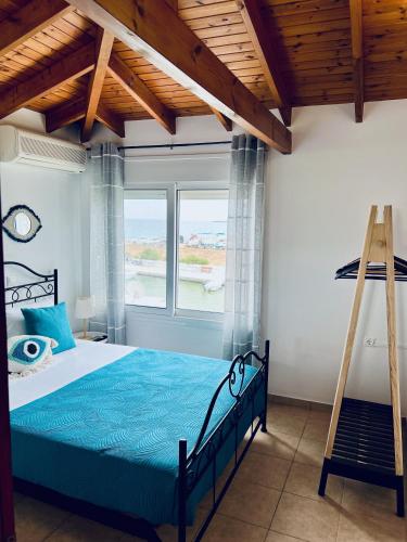 a bedroom with a blue bed and a ladder at Thalassia Avra Stegna Beach in Archangelos