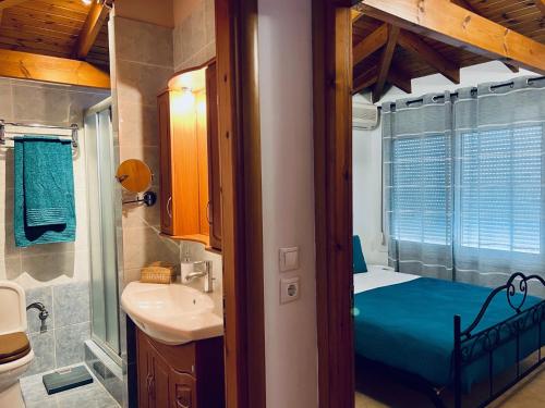 a small bathroom with a bed and a sink at Thalassia Avra Stegna Beach in Archangelos