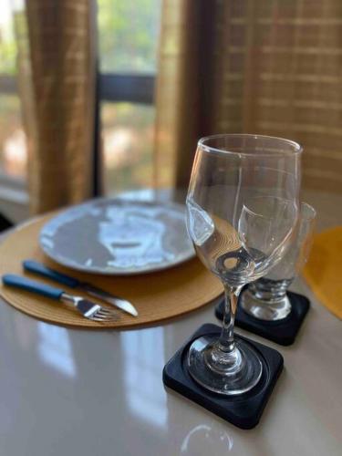 uma mesa com dois copos de vinho e um prato em Apartamento Salvador em Salvador