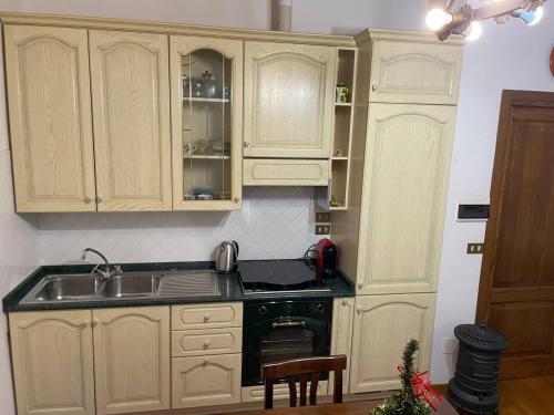 a kitchen with white cabinets and a sink and a stove at La Casina di Maya in Livorno