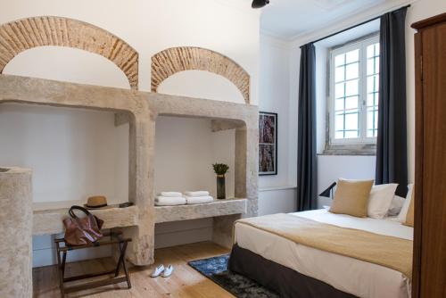 a bedroom with a large bed and two windows at Madalena Orquidea Living Apartments in Lisbon
