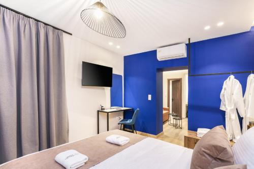 a hotel room with a blue accent wall at Princess of Axos Luxury Suites in Axós