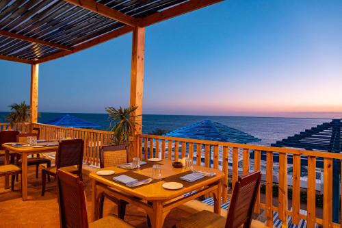 una terraza con mesas y sillas y el océano en Grand Oasis Resort, en Sharm El Sheikh