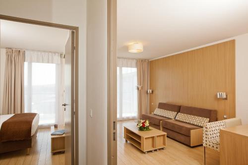 une chambre d'hôtel avec un canapé et un lit dans l'établissement Residhome Carrières La Défense, à Carrières-sur-Seine