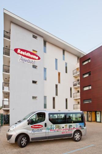 a silver van parked in front of a building at Residhome Carrières La Défense in Carrières-sur-Seine