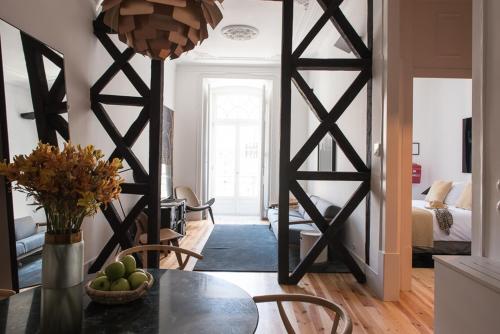 a living room with a table with a vase of fruit at Madalena Orquidea Living Apartments in Lisbon