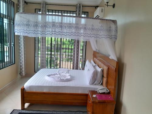 a bedroom with a bed with a window and a bed sidx sidx sidx at WILIVINA HOTEL in Dar es Salaam
