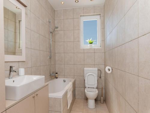 a bathroom with a sink and a toilet and a window at Holiday Home Lea in Maslinica