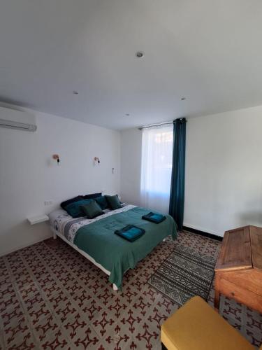 une chambre avec un lit et une table en bois dans l'établissement La Petite Maison des Boettes, à Carpentras