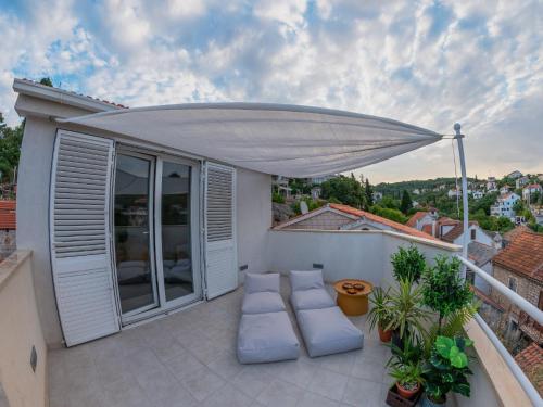 a patio with a white umbrella on a balcony at Holiday Home Lea in Maslinica