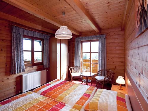 a bedroom with a bed and a table and windows at Cosy holiday home near ski area in Wagrain