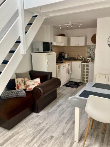 un salon avec un canapé et une cuisine dans l'établissement Appartement duplex lumineux idéalement situé, à Arès