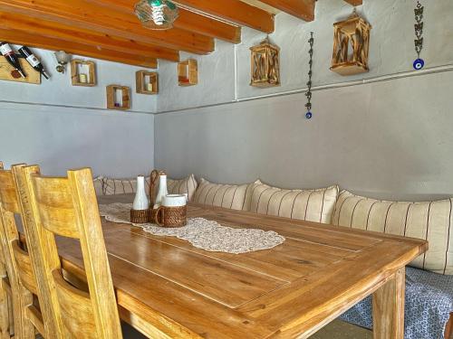 艾瓦勒克的住宿－Eolya Konuk Evi，一间带木桌和沙发的用餐室
