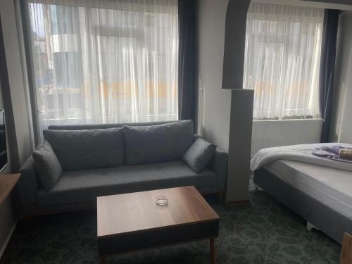 a living room with a couch and a bed and a table at Samsun Otel Vidinli in Samsun