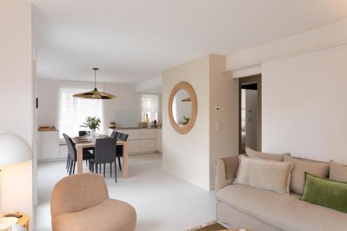 ein Wohnzimmer mit Sofa und Tisch in der Unterkunft Villa l'Indépendante - Proche de la plage in Dinard