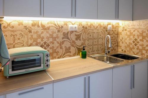 a kitchen counter with a microwave and a sink at NGsuite cityspot Volos in Volos