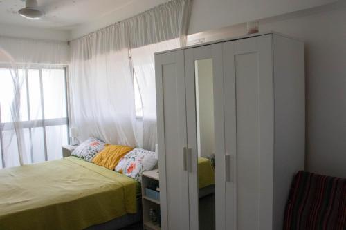 a small bedroom with a bed and a cabinet at Serene Sea View By Chana in Colombo