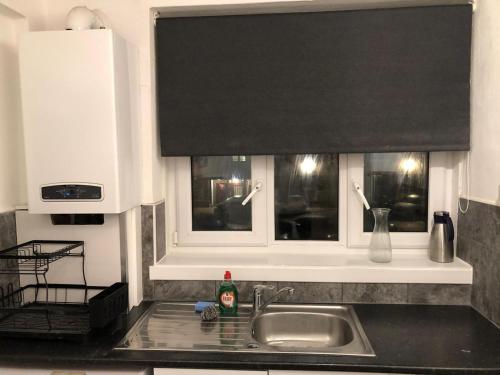 a kitchen counter with a sink and a window at Lovely 3 bedroom North london in London