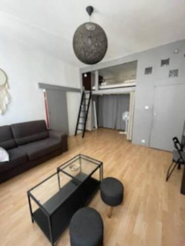 - un salon avec un canapé noir et une table en verre dans l'établissement Joli T1+ bien situé dans le 6ème de Marseille, proche commodités, à Marseille