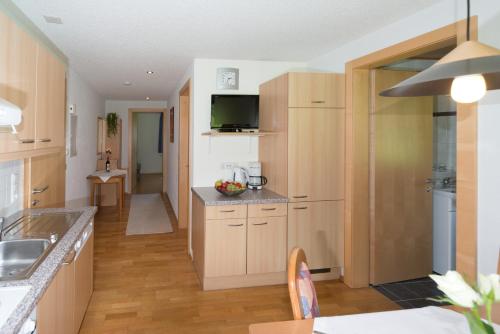 cocina con armarios de madera y encimera en Appartements Moosbrugger Haus Herlinde en Schoppernau