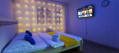 a purple room with a bed with a television at Апартаменты в центре города in Aktobe
