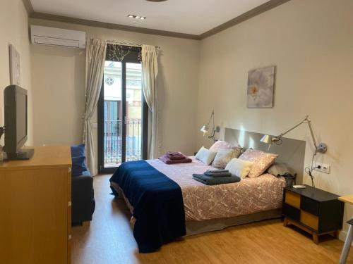 Schlafzimmer mit einem Bett, einem TV und einem Fenster in der Unterkunft Spatious luxe apartment Paseo de Gracia Diagonal in Barcelona