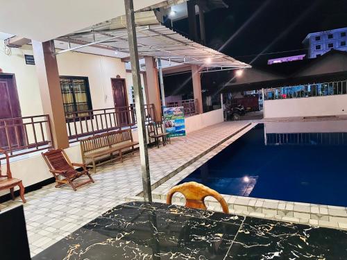 a swimming pool with a chair in the middle of it at Vang Vieng Global Hostel in Vang Vieng