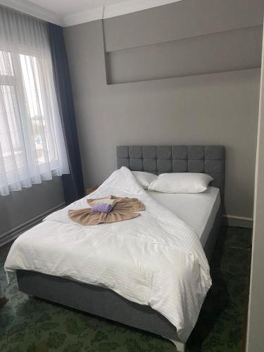 a bed with a robe on it in a bedroom at Samsun Otel Vidinli in Samsun