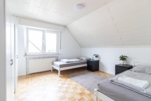 ein weißes Schlafzimmer mit einem Bett und einem Fenster in der Unterkunft Ferienwohnung/Messewohnung in Köln