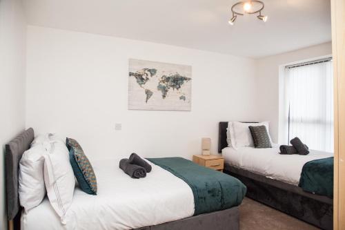 a bedroom with two beds and a world map on the wall at PENTHOUSE - LIVERPOOL City Centre & Royal Hospital Location in Liverpool